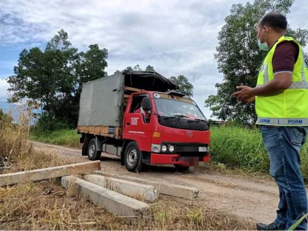 Timbalan Ketua Balai Polis Simpang, Sarjan Helmi Mat Rejab memeriksa kenderaan yang menggunakan laluan tikus di Taman Kota Permai, Taiping selepas cerucuk konkrit yang digunakan sebagai halangan telah dialihkan pada Isnin.