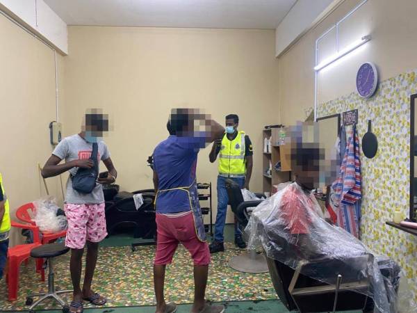 Polis membuat pemeriksaan di sebuah kedai gunting rambut di Bahau.