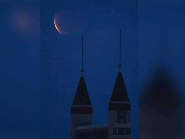 Gerhana bulan penuh atau 'Super Flower Blood Moon' yang diliputi awam dirakam berlatarkan Jambatan Angkat Kuala Terengganu di Kampung Seberang Takir ketika tinjauan malam ini.  Foto Bernama