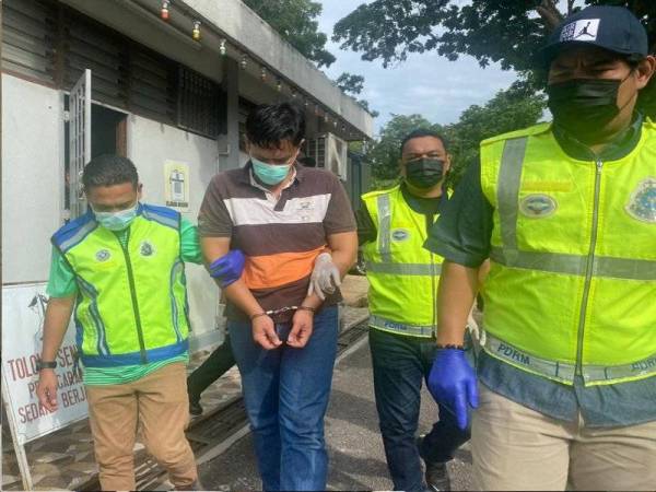 Tertuduh ketika dibawa keluar dari Mahkamah Majistret Jasin pada khamis.