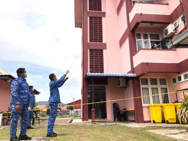 Penyelaras Stesen Kuarantin Kelantan, Kapten (PA) Muhammad Shafie Rosslee (tengah) bercakap dalam jarak jauh dengan PUS yang ditempatkan di tingkat satu bangunan di QS Sektor Sumber Teknologi Pendidikan, Pengkalan Chepa, Kota Bharu.