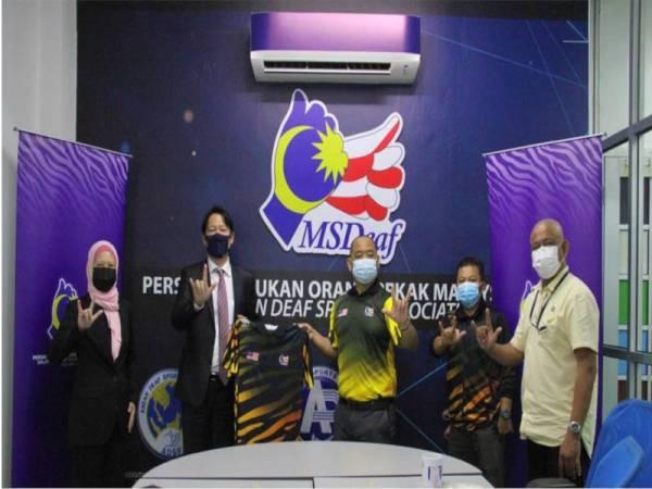 Hamada (dua dari kiri) serah penajaan kepada skuad Harimau Pekak Malaysia. -Foto Yakult Malaysia