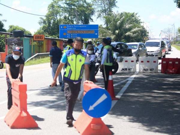 Anggota penguat kuasa menyusun penghadang jalan sebagai persiapan PKPD di mukim Kuala Berang bermula Sabtu.