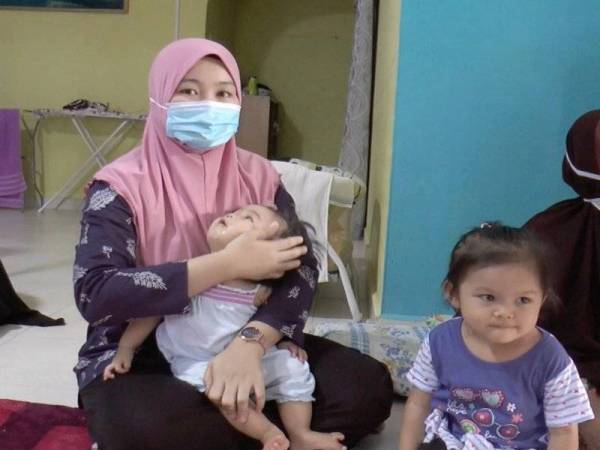 Noorfadilah meriba anaknya, Wan Nursyifaadelia disamping anak sulungnya, Wan Nursofiaazzahra.