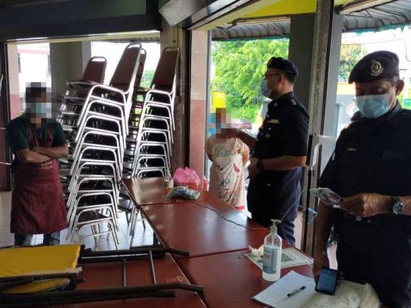 Polis membuat pemeriksaan di sebuah premis sebelum kompaun dikeluarkan.