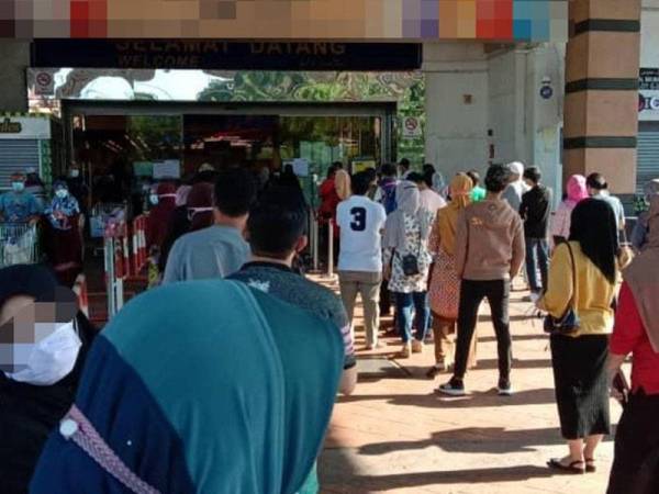 Pelanggan beratur menunggu giliran untuk memasuki sebuah pasar raya di Kuala Terengganu. - Foto ihsan pembaca