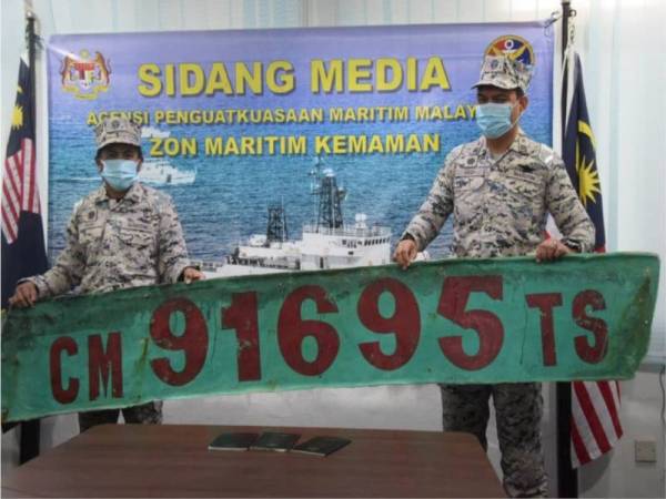 Pengarah Zon Maritim Kemaman, Komander Maritim Rashidilhadi Abd Rashid (kanan) menunjukkan nombor pendaftaran palsu digunakan nelayan asing yang ditahan perairan Terengganu pada Khamis. Foto Ihsan Maritim Kemaman