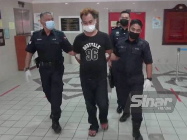 Tertuduh (tengah) dihadapkan ke Mahkamah Majistret Kuala Terengganu pada Isnin atas dakwaan mencederakan dan melakukan kekerasan jenayah terhadap tiga individu di sebuah kedai serbaneka pada Khamis.