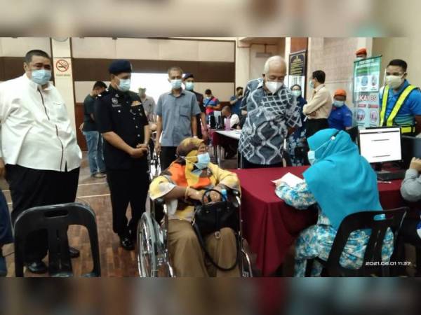 Mahdzir (berdiri, dua dari kanan) meninjau situasi di PPV Dewan Tunku Putra, Kuala Nerang pada Selasa. - Foto MDPT