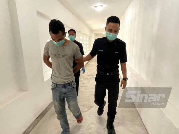 Tertuduh (kiri) dikawal polis keluar dari lokap Mahkamah Kota Bharu menuju ke bilik Mahkamah Sesyen Kota Bharu bagi mendengar pertuduhan yang dikenakan terhadapnya atas dakwaan merogol seorang remaja perempuan.