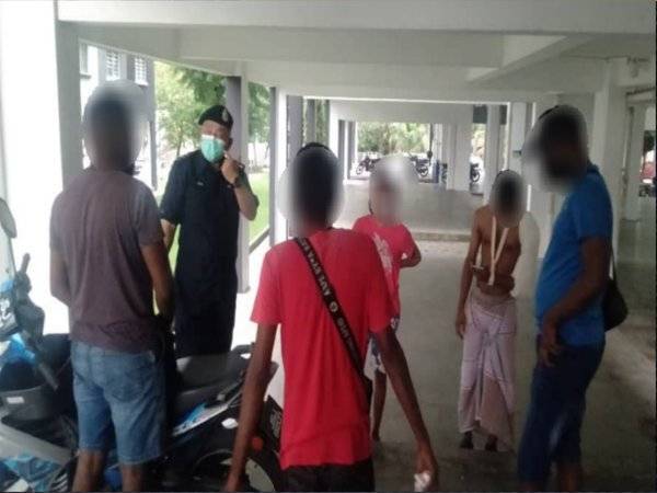 Lima individu yang dikompaun kerana melepak tanpa penjarakan fizikal dan tidak memakai pelitup muka di sebuah flat di Taman Pelangi Indah, Johor Bahru pada Rabu. - Foto Polis JBS