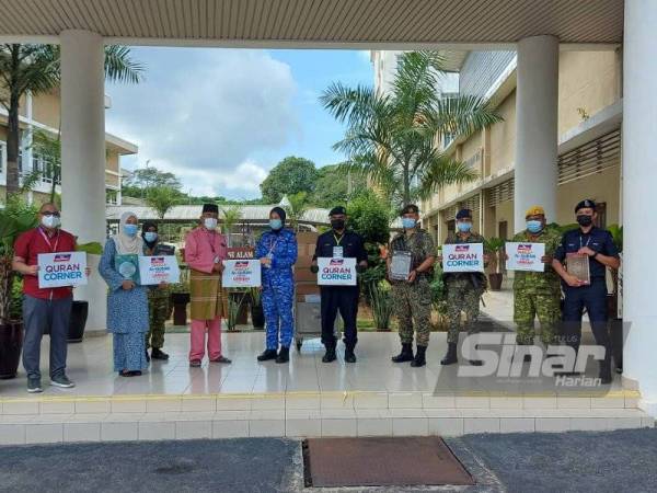 Hashim (tiga dari kiri) menyampaikan wakaf al-Quran di PKRC Kuala Pilah pada Jumaat.