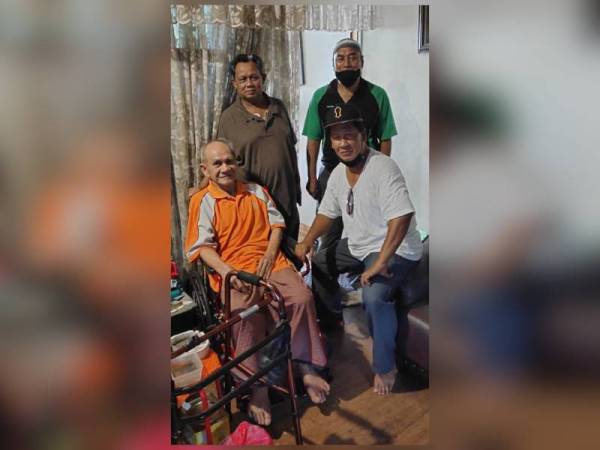 Abdul Rahman (duduk, kiri) bergambar bersama rakan-rakannya yang berkunjung ke rumahnya di Seksyen 18, Shah Alam.
