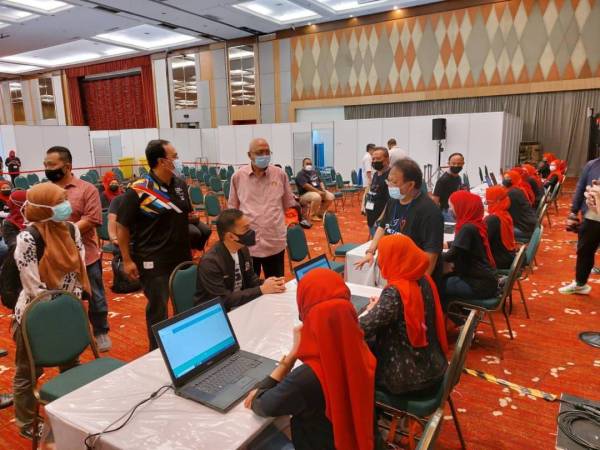 Mohd Noh (berdiri, kanan) dan Onn Hafiz (duduk) meninjau persiapan dan kemudahan PPV di Pusat Konvensyen Antarabangsa Persada Johor, Johor Bahru, pada Sabtu.