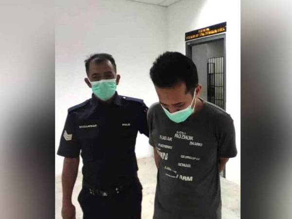 Tertuduh dikawal ketat polis ketika keluar dari bilik Mahkamah Majistret Kota Bharu menuju ke lokap.