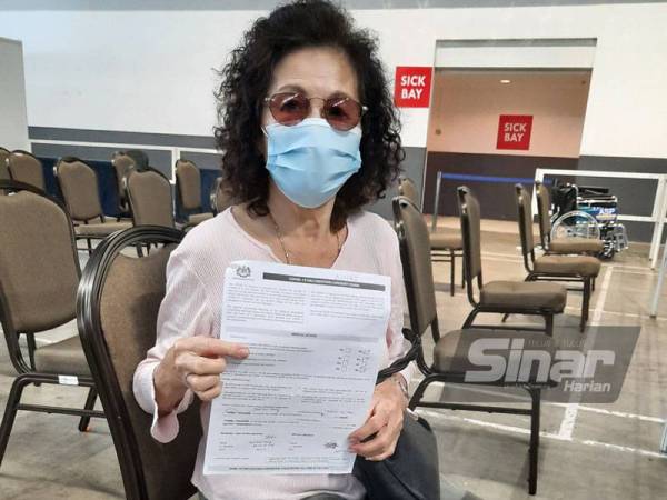 Hooi Kheng menunjukkan borang penerimaan vaksin ketika ditemui pada Isnin.