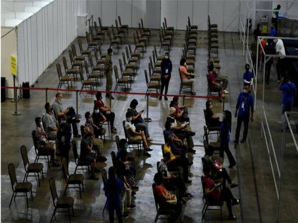 Orang ramai menunggu giliran untuk mendapat suntikan vaksin Covid-19 di Pusat Pemberian Vaksin (PPV) Setia Spice Arena Bayan Lepas, pada Isnin. -Foto Bernama