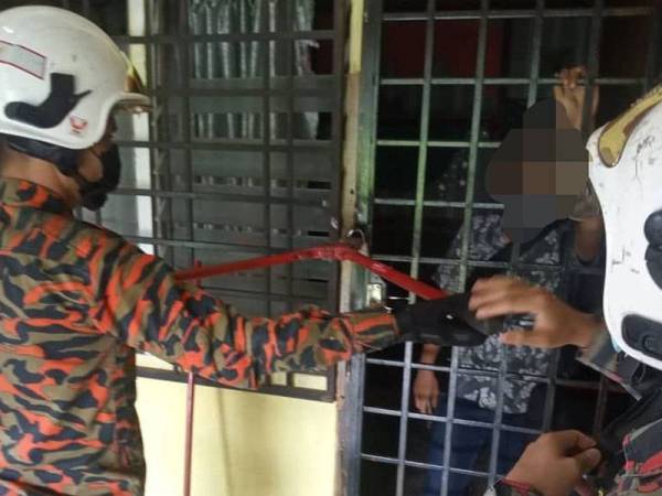 Anggota bomba menggunakan peralatan khas untuk memecahkan mangga pintu dalam kejadian di Kota Tinggi pada Rabu.