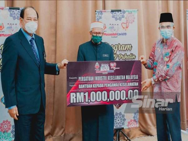 Simbolik penyerahan disampaikan Daud (kanan) kepada Ramli sambil disaksikan oleh Zulkifli (tengah) di Lobi Kompleks Islam Putrajaya pada Khamis.