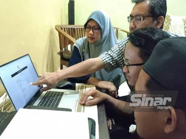 Ahmad Haziq (dua dari kanan) gembira ketika melihat keputusan cemerlangnya bersama keluarga di rumahnya di Bukit Setongkol pada Khamis.