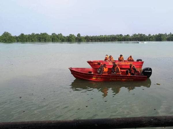 Anggota bomba mengangkat mayat seorang lelaki yang ditemukan lemas selepas terjun dalam sungai di Jeti BBP Muar, Muar pada Khamis.