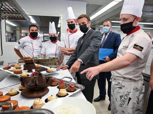 Macron (dua dari kanan) melawat para pelajar yang mengikuti latihan bekerja di hotel dan restoran di sebuah sekolah tinggi sebelum beliau ditampar oleh Damien T. di Tain-L'Hermitage, tenggara negara tersebut pada Selasa lalu. - Foto AFP