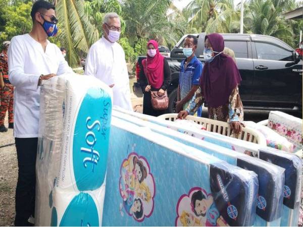 Noh (dua dari kiri) menyampaikan sumbangan kepada ahli keluarga mangsa kebakaran pada Jumaat