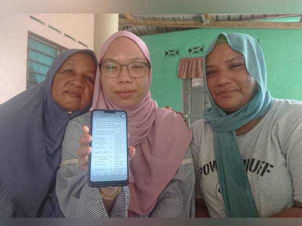 Nurul Eisha (tengah) berkongsi kegembiraan bersama ibu dan neneknya di rumah mereka di Kampung Bukit Balai, Durian Tunggal, di sini pada Ahad.