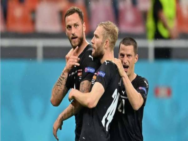Penjaring gol ketiga Austria, Marko Arnautovic diraikan rakan-rakan sepasukan.