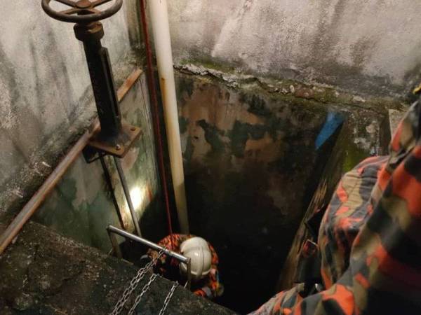 Anggota bomba membantu mengeluarkan seorang pekerja penyelenggaraan pasar raya yang dipercayai terjatuh ke dalam lubang saluran kumbahan di Batu Pahat pada Ahad.