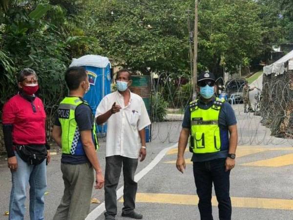 Anuar (kanan) meninjau kawasan PKPD Kampung Sungai Penchala, Kuala Lumpur pada Sabtu.