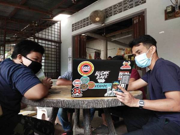 Mohammad Helmi (kanan) bersama anak-anak penduduk kampung terpaksa berdepan dengan masalah internet lemah dan menyukarkan mereka untuk mengikuti sesi pembelajaran.