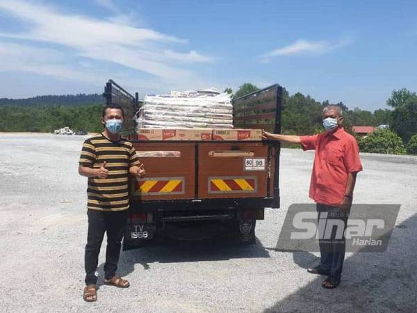Nik Dir (kanan) bersama barangan keperluan untuk diagihkan kepada golongan terjejas yang tercicir daripada menerima bantuan Covid-19.