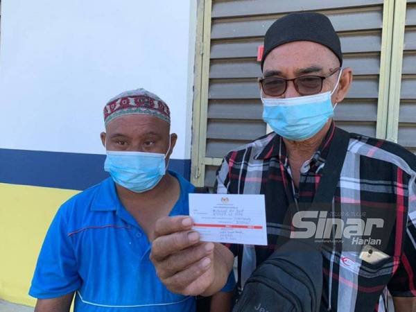 Shahriemy (kiri) menemani bapanya menerima suntikan vaksin di PPV IKBN, Tanah Merah.