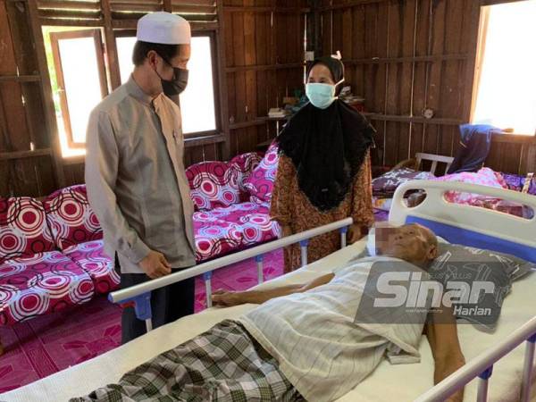 Abdul Aziz (kiri) menyumbangkan katil khas kepada Nawi.