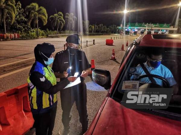 Ahmad Shukri memeriksa dokumen kebenaran rentas daerah oleh seorang pemandu yang melalui SJR di Tol Alor Setar Selatan.