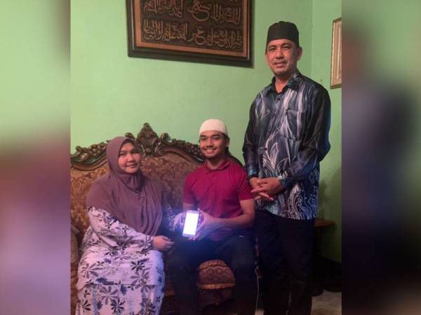 Amnan bersama kedua ibu bapanya di Kampung Padang Enggang, Kota Bharu menunjukkan keputusan STAM yang diumumkan pada Khamis.