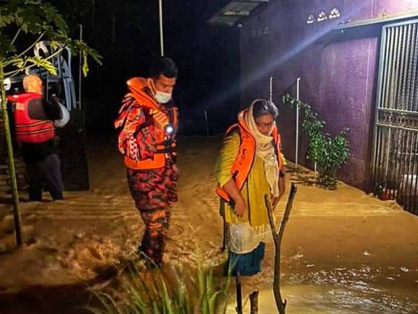 Anggota bomba dari BBP Kuala Lipis menyelamatkan pasangan warga emas terperangkap banjir kilat di Kampung Kuala Lanar, Kuala Lipis pada Khamis. - Foto: Ihsan Bomba