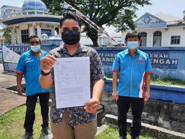 Salah seorang wakil cabang PKR Pulau Pinang menunjukkan laporan polis yang dibuat terhadap Takiyuddin secara serentak pada Jumaat.