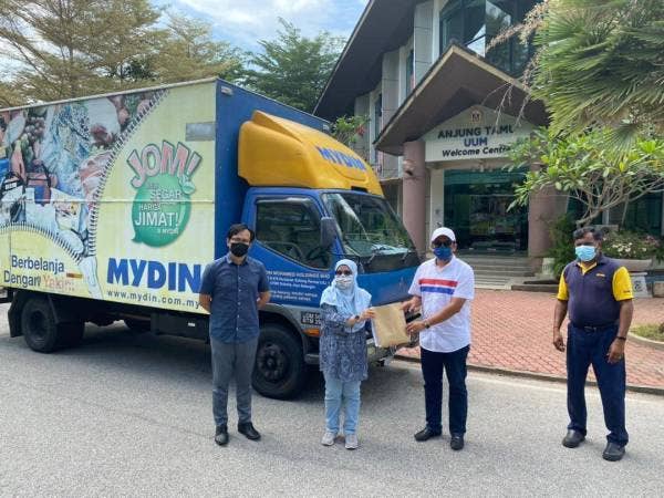 Wakil alumni, Zamri Mat (dua dari kanan) menyerahkan sumbangan barangan makanan untuk warga UUM kepada Pengarah Bahagian Perkhidmatan Sokongan Pelajar, Profesor Madya Dr Rajwani Md Zain di hadapan pintu masuk UUM pada Jumaat.