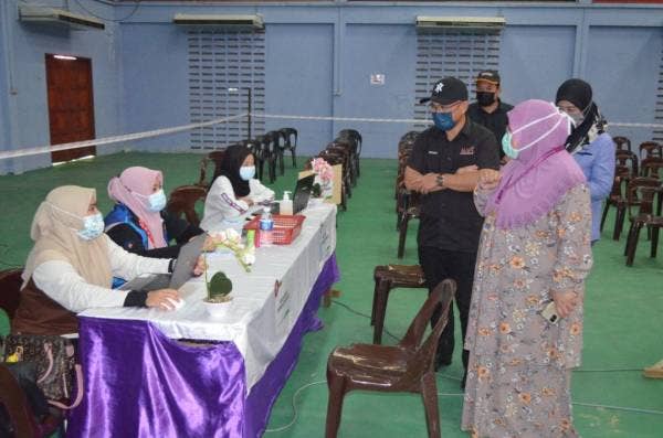 Ronald (dua dari kanan) melawat PPV Dewan Serbaguna Pekan Beluran untuk melihat sendiri proses vaksinasi yang dijalankan di bawah kawasan Parlimen Beluran.