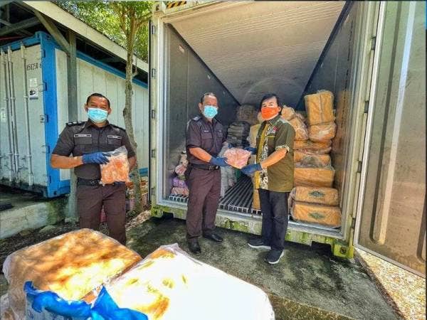 Roslan (dua dari kiri) menyerahkan ayam sejuk beku yang telah dilucut hak oleh Maqis Kelantan kepada wakil Zoo Negara pada Ahad.