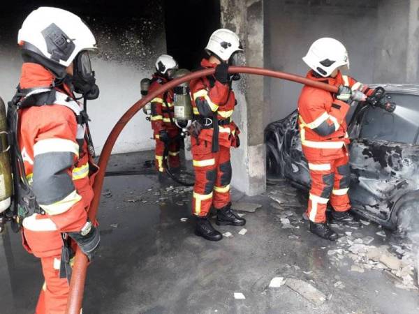 Anggota bomba memadamkan kebakaran dalam kejadian pada petang Ahad.