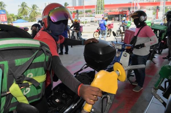Beberapa penghantar makanan dan barangan bermotosikal (rider) menunggu giliran di Stesen Minyak Petron,Taman Pelangi hari ini. -Foto Bernama
