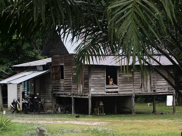 Seorang kanak-kanak melambai tangan ke arah jurufoto semasa gambarnya dirakam ketika berada di dalam rumah sepanjang pelaksanaan Perintah Kawalan Pergerakan Diperketatkan (PKPD) di Kampung Lakai, hari ini.