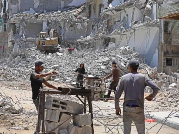 Beberapa pekerja sedang mengumpulkan logam yang mungkin boleh digunakan semula. - Foto: Agensi