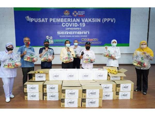 Ahmad (tengah) menyampaikan sumbangan MAFI prihatin kepada petugas di PPV Seremban pada Isnin.