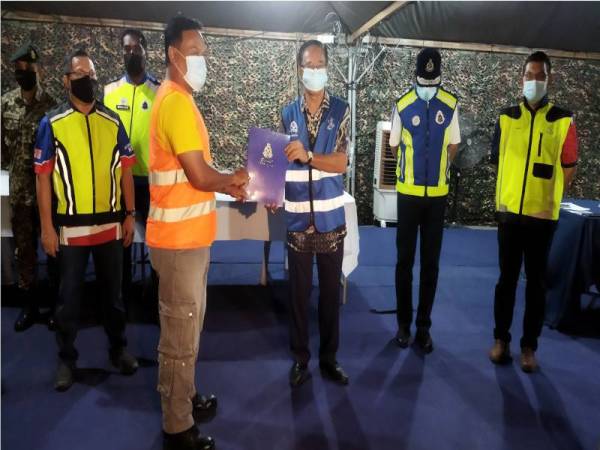 Mohamad Noor (dua kanan) mengiringi Khairuddin menyampaikan sijil penghargaan kepada Pengerusi JKKK Seri Damai, Mohd Amiruddin Mat Isa mewakili PKP Seri Damai selepas tugasan PKPD di kawasan itu tamat pada tengah malam Isnin.