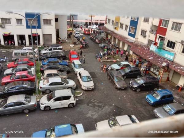 Penduduk beratur bagi membeli barang keperluan di sebuah kedai runcit dalam kawasan PKPD di Perumahan Awam Desa Rejang Setapak, Kuala Lumpur pada Selasa.