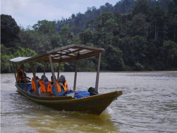 Petugas barisan hadapan Pusat Kesihatan Daerah (PKD) Jerantut mengharungi sungai dengan menaiki bot untuk ke Kampung Orang Asli Sungai Kucing pada program Vaksinasi Masyarakat Orang Asli Ulu Tembeling. - Foto Bernama